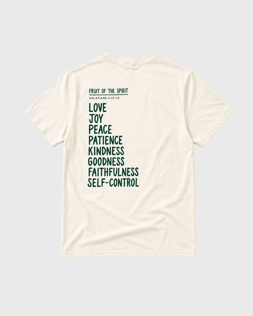 An off-white short-sleeve t-shirt shown from the back, featuring a dark green printed list of biblical virtues (Love, Joy, Peace, Patience, Kindness, Goodness, Faithfulness, Self-Control) under the heading 'FRUIT OF THE SPIRIT' and 'MATTHEW 5:3-10'.