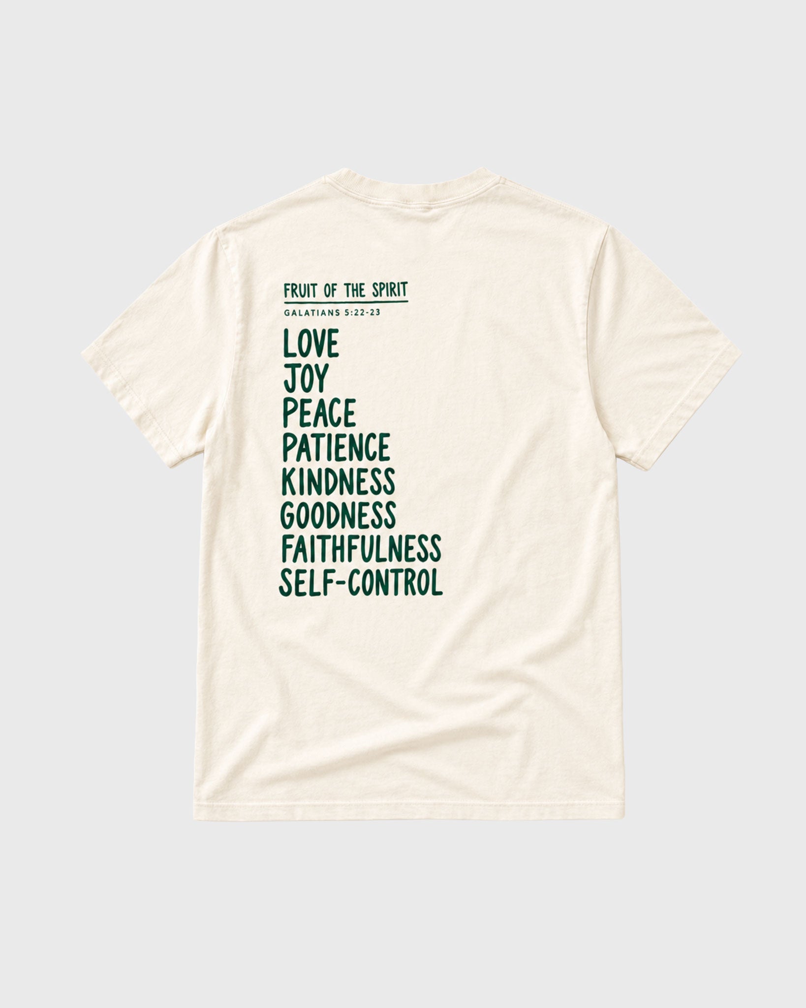 An off-white short-sleeve t-shirt shown from the back, featuring a dark green printed list of biblical virtues (Love, Joy, Peace, Patience, Kindness, Goodness, Faithfulness, Self-Control) under the heading 'FRUIT OF THE SPIRIT' and 'MATTHEW 5:3-10'.